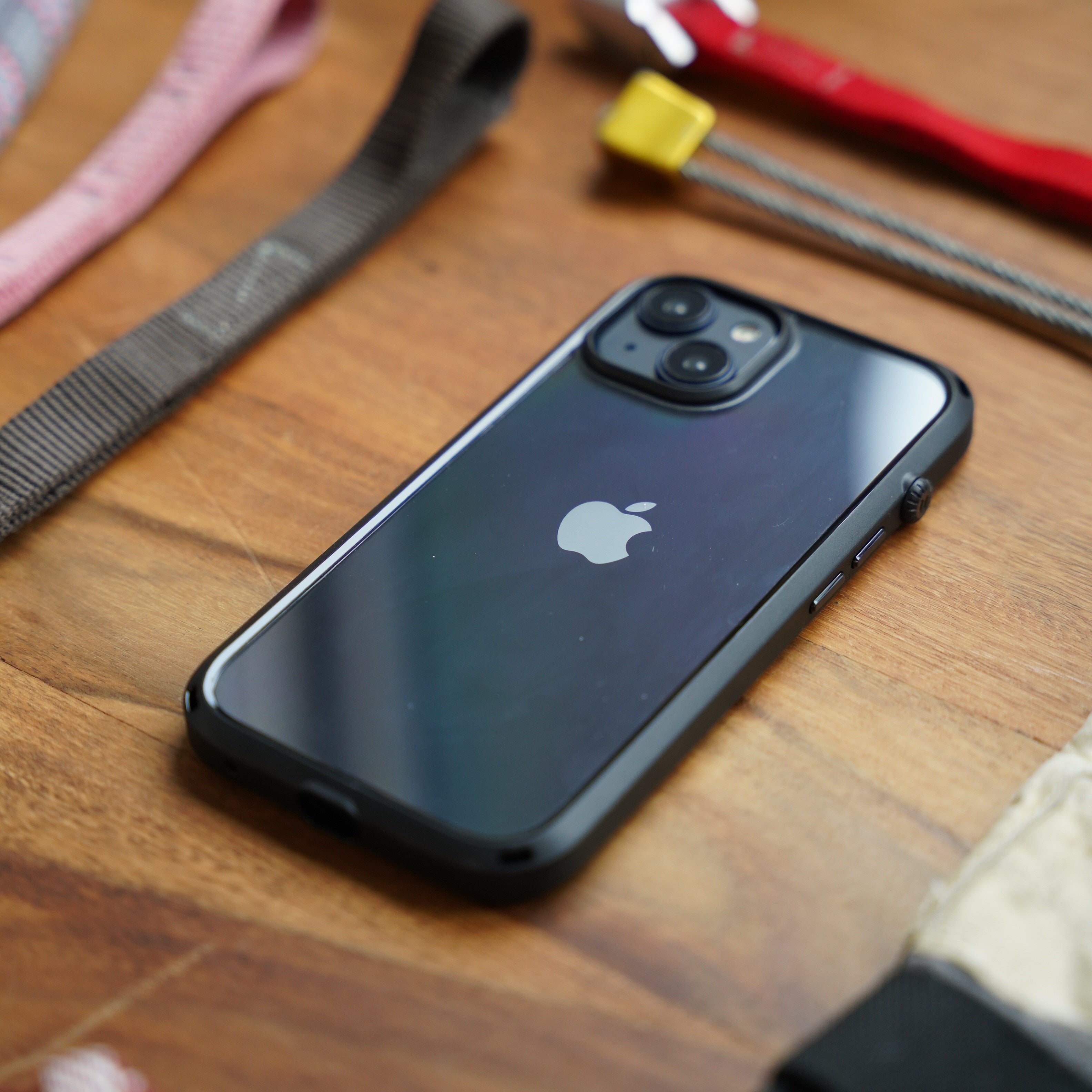 Catalyst Drop Proof Case placed on a wooden surface surrounded by climbing gear including ropes, harnesses, and a carabiner.