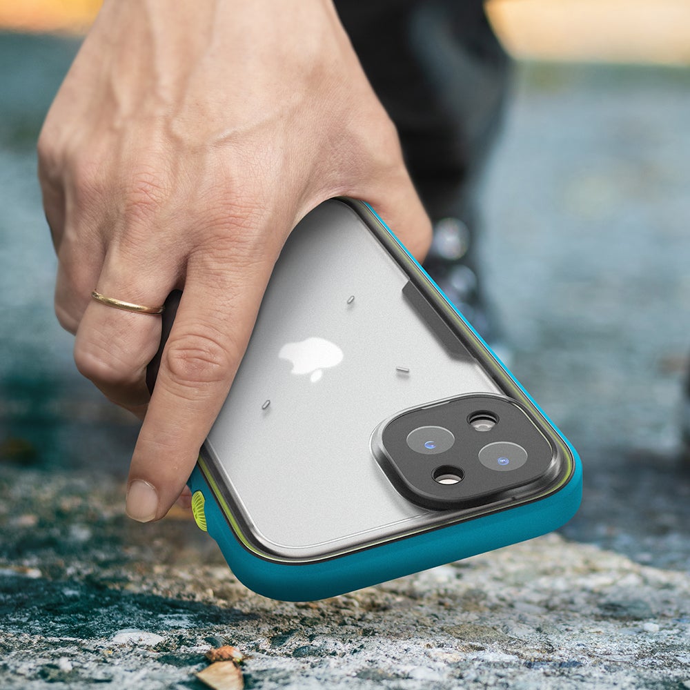 Catalyst Waterproof Total Protection case for iPhone 13 series showing a hand picking up the iphone with the catalyst total protection case installed