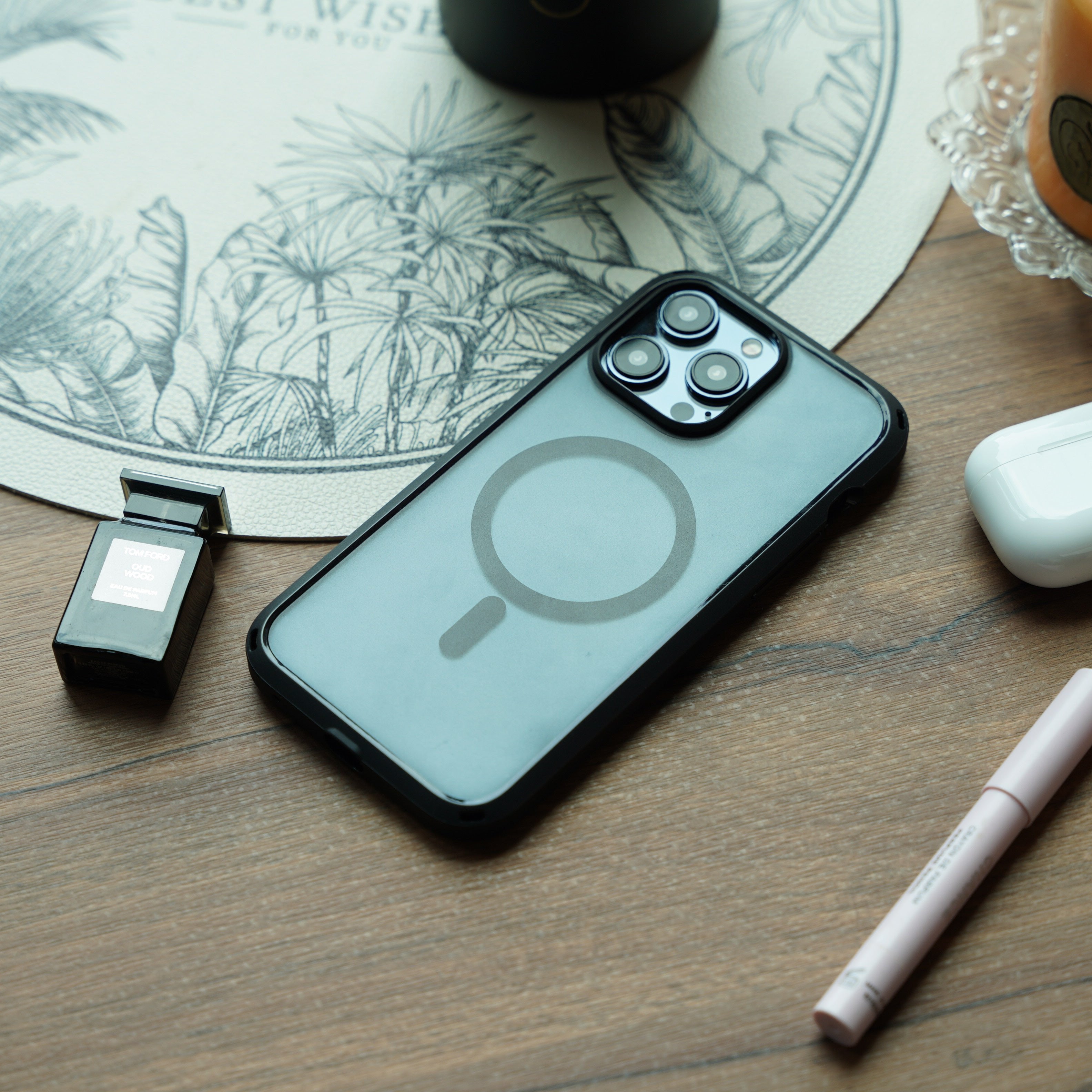 iphone drop proof case magsafe compatible black on the table near an orange candle, airpods, perfume and makeup